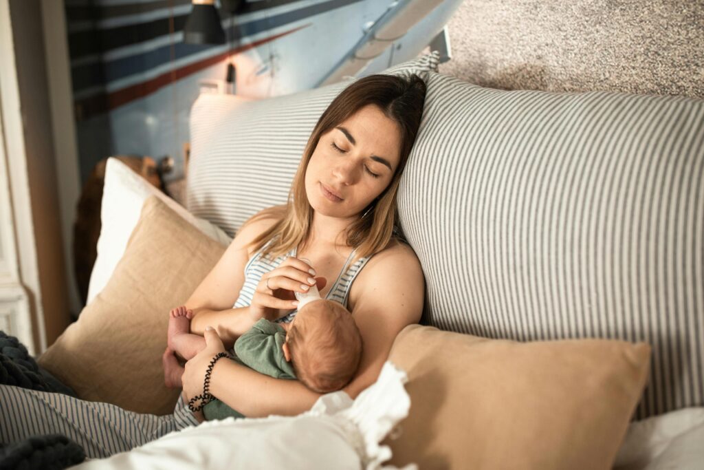 Tired mom bottle feeding baby
